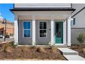 Close up of front entrance with a vibrant green door, neat landscaping, and inviting curb appeal at 108 Black Gum Unit 38 Ln, Auburn, GA 30011