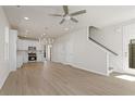 Bright, open-concept living space features light wood floors, a modern ceiling fan, and staircase at 108 Black Gum Unit 38 Ln, Auburn, GA 30011