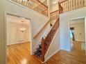 Grand two-story entryway with staircase, hardwood floors, and chandelier view into a living space at 5960 Camelia Dr, Douglasville, GA 30135