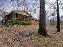 View of a screen porch on a brick house with a spacious, tree-filled backyard at 5865 Leah Lane Ln, Powder Springs, GA 30127