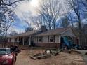 View of a single-story brick and vinyl-sided home with a covered front porch, lawn equipment and a red convertible at 5865 Leah Lane Ln, Powder Springs, GA 30127