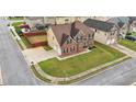 Aerial view of a well-manicured property featuring a two-story brick home, green lawn, and fenced backyard at 106 Dustin Dr, Stockbridge, GA 30281