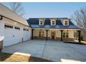 Stunning modern farmhouse with a three-car garage and inviting covered porch and craftsman-style details at 105 Crown Ln, Woodstock, GA 30188