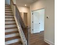 Welcoming entryway featuring staircase with wooden treads, black iron railing and warm hardwood floors at 2257 Addington Way # 56, Atlanta, GA 30319