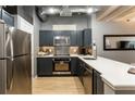 Modern kitchen with stainless steel appliances, dark cabinets, and light countertops at 32 Peachtree Nw St # 1105, Atlanta, GA 30303