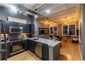 Stylish kitchen with stainless steel appliances, dark cabinets, and open layout to the living area at 32 Peachtree Nw St # 1105, Atlanta, GA 30303