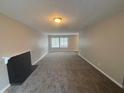 Spacious living room with neutral carpet, a fireplace, and large windows for ample natural light at 5073 Martins Crossing Rd, Stone Mountain, GA 30088