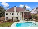 Back exterior of home with screened porch overlooking a private pool and well-maintained backyard at 635 Piping Rock Pt, Lawrenceville, GA 30043
