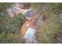 Aerial view of the property showcasing a swimming pool and surrounding trees at 1106 Oak Sw Rd, Lilburn, GA 30047