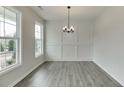 Elegant dining room with decorative chandelier, wainscoting, and large windows at 2554 Hickory Valley Dr, Snellville, GA 30078