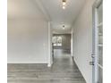 Inviting home hallway with gray wood-look floors, neutral walls, and modern lighting fixtures at 2554 Hickory Valley Dr, Snellville, GA 30078