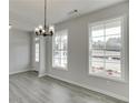 Inviting dining area with natural light from large windows and a stylish chandelier creating a cozy atmosphere at 2594 Hickory Valley Dr, Snellville, GA 30078