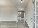 Light-filled entryway with modern gray wood-look floors and a stylish door, creating a welcoming entrance at 2594 Hickory Valley Dr, Snellville, GA 30078