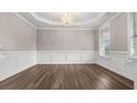 Formal dining room with elegant chandelier, wainscoting, and ample natural light at 1315 Thunder Gulch Pass, Suwanee, GA 30024