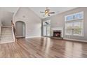 Bright living room featuring vaulted ceilings, a cozy fireplace, and gleaming hardwood floors at 1315 Thunder Gulch Pass, Suwanee, GA 30024