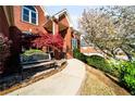 Welcoming front entrance with a bench, colorful landscaping and a brick walkway leading to the covered porch at 1574 Stepstone Way, Lawrenceville, GA 30043