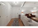 Bright hallway featuring hardwood floors, white walls, and neutral furnishings that leads into the cozy living room at 1735 Peachtree Ne St # 227, Atlanta, GA 30309