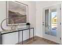 Elegant entryway featuring a console table with decorative accessories and a glass-paneled front door at 325 Sassafras W Way, Holly Springs, GA 30115