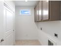 Functional laundry room with overhead cabinets and ample storage space at 325 Sassafras W Way, Holly Springs, GA 30115