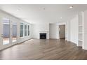Bright, open living room with hardwood floors, fireplace, and access to the patio at 325 Sassafras W Way, Holly Springs, GA 30115