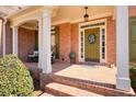 Charming brick porch featuring rocking chairs and a welcoming olive front door at 586 Devon Brooke Dr, Woodstock, GA 30188