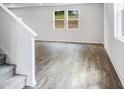 Bright living room featuring hardwood floors and large windows overlooking the outdoors at 203 Groveton Ct, Euharlee, GA 30145