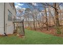 Large backyard with an outdoor staircase and a mix of grass and natural woodland surroundings at 3669 Clearbrooke Way, Duluth, GA 30097