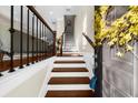 Inviting townhouse entryway with wood and white stairs and modern iron railing detail at 4478 Dunblane Ave, Sugar Hill, GA 30518