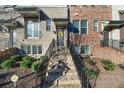 Exterior view of a townhouse featuring well-maintained landscaping, a brick entryway, and inviting front door at 4478 Dunblane Ave, Sugar Hill, GA 30518