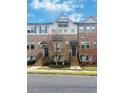 Charming brick townhomes featuring private entries with staircases and a well-maintained lawn under a blue sky at 4478 Dunblane Ave, Sugar Hill, GA 30518