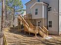 Back of house showing wooden deck, stairs, and shaded backyard at 703 Sierra Ct, Canton, GA 30114