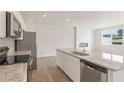 Modern kitchen with granite countertops, stainless steel appliances, and wood flooring at 982 Sutherland Ln (Lot 30), Lawrenceville, GA 30043