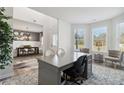 Bright home office with a large desk and views of the outdoors through bay windows at 117 Longhorn Way, Auburn, GA 30102