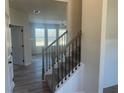 A carpeted staircase with iron spindles leads to the upper level in this bright, modern home with wood-look floors at 117 Longhorn Way, Auburn, GA 30102