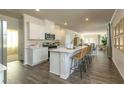 Modern, open-concept kitchen with white cabinets, a large island with seating, and stainless steel appliances at 2402 Bayberry St, Acworth, GA 30101