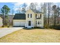 Inviting two-story home with attached garage, set against a backdrop of trees at 581 Victorian Cir, Dallas, GA 30157