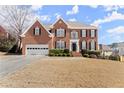 Traditional brick home with manicured lawn, 2-car garage, and charming front entry at 602 Kenion Forest Way, Lilburn, GA 30047