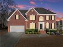 Elegant brick home at twilight with manicured landscaping and inviting curb appeal at 602 Kenion Forest Way, Lilburn, GA 30047