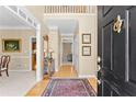 Inviting home foyer with hardwood floors, elegant rug, and a view to the upper level at 602 Kenion Forest Way, Lilburn, GA 30047