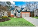 Charming two-story home with enhanced green front yard and attached two-car garage at 608 Ridge Crossing Dr, Woodstock, GA 30189