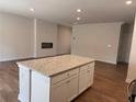 Kitchen island features granite countertops and a large open concept living area with a fireplace at 986 Sutherland Ln (Lot 32), Lawrenceville, GA 30043