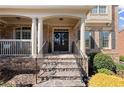 Inviting front porch with stone steps and stately columns leading to the front door at 112 Rocky Creek Trl, Woodstock, GA 30188