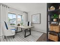 Bright home office featuring large windows, stylish furniture, decor, and a neutral color palette at 3071 Birdsong Ave, Covington, GA 30016