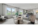Open-concept living space with a large sectional sofa, hardwood floors, and natural light at 3071 Birdsong Ave, Covington, GA 30016