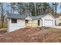 Quaint home with a new porch, front facing garage, and fresh, light-colored siding at 6276 Willowbrook Dr, Riverdale, GA 30296