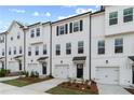 Townhouse exterior showcasing white siding, black accents, garages, and newly planted landscaping at 3156 Washburn Sw St, Atlanta, GA 30354