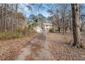 Two-story home with neutral siding and a long driveway surrounded by tall trees at 1791 Lake George Dr, Lithia Springs, GA 30122