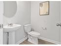 Elegant half-bathroom featuring a pedestal sink and decorative artwork at 1029 Northfield Dr, Conyers, GA 30013