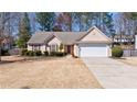Charming single-story home with a well-maintained lawn, an attached two-car garage, and a neatly landscaped front yard at 7350 Brassfield Dr, Cumming, GA 30041