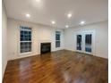 Bright living room featuring a fireplace, hardwood floors, recessed lighting, and access to the outdoors at 175 Stillwood Dr, Fayetteville, GA 30215